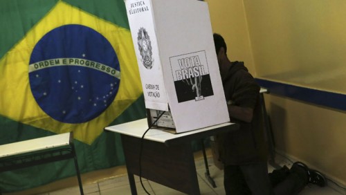 Un hombre se arrodilla en una cabina de votaciÃ³n para emitir su sufragio en las elecciones generales de Brasil en un local de votaciÃ³n en Sao Bernardo do Campo, cerca de Sao Paulo